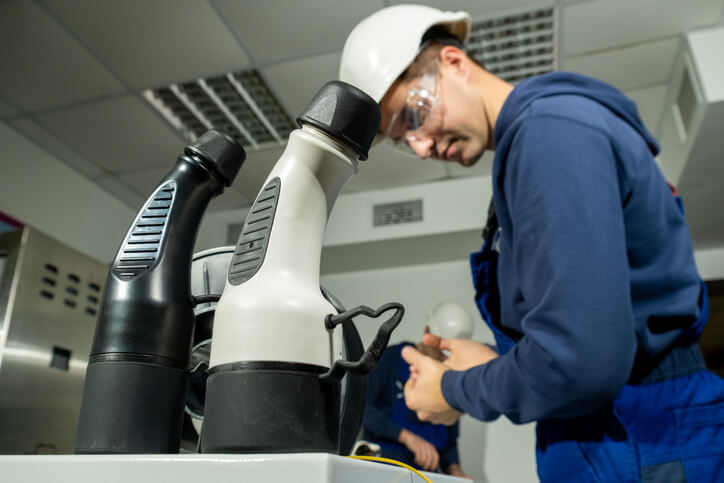 A student learning about EV charging connectors during hybrid technology training at ATC Surrey