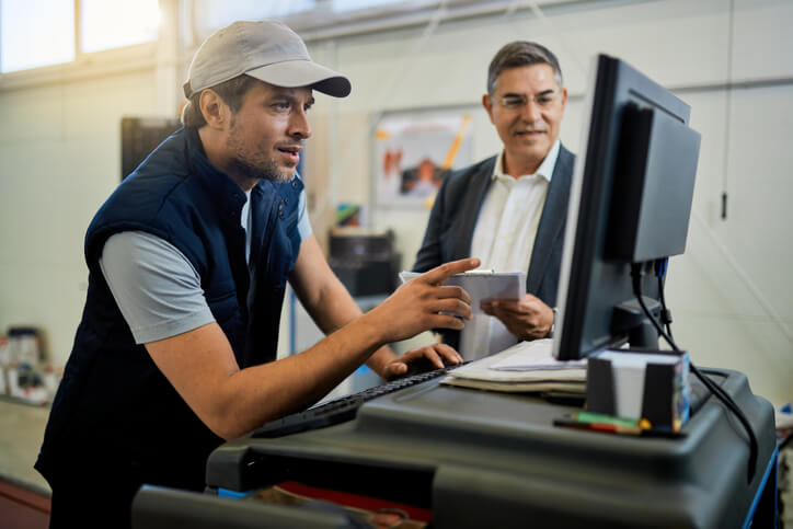An auto mechanic school in Surrey student interacting with a customer during training