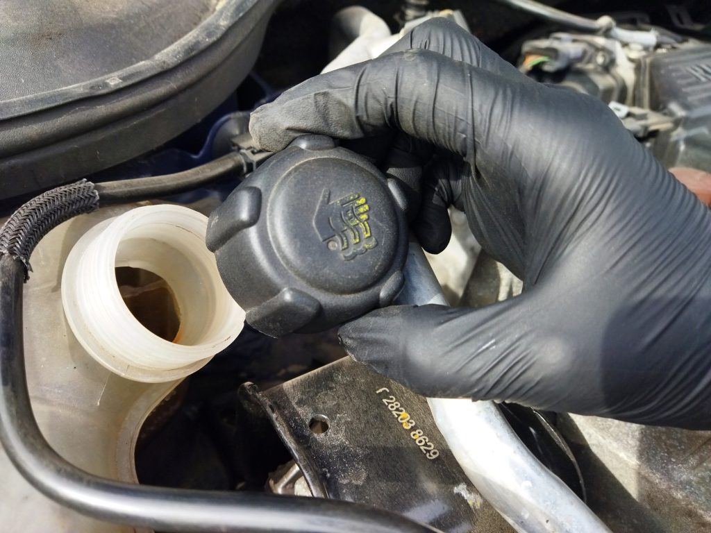 Technician checking coolant levels and engine temperature