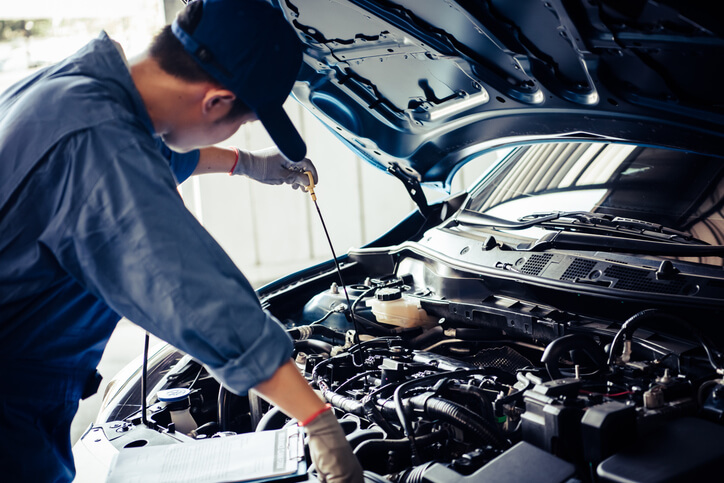 Auto mechanic school instructor demonstrating how to check engine oil viscosity in low temperatures in a Montreal garage.