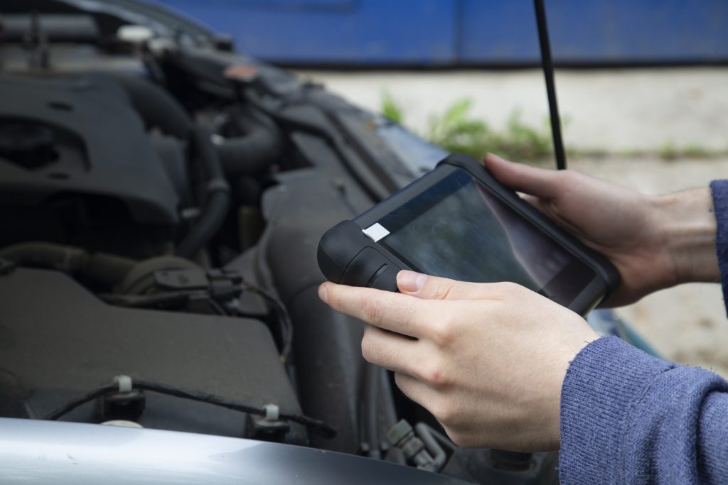 Automotive technician using a scan tool on a modern vehicle