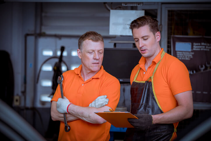An aspiring mechanic demonstrating teamwork and safety during an engine diagnostics session.