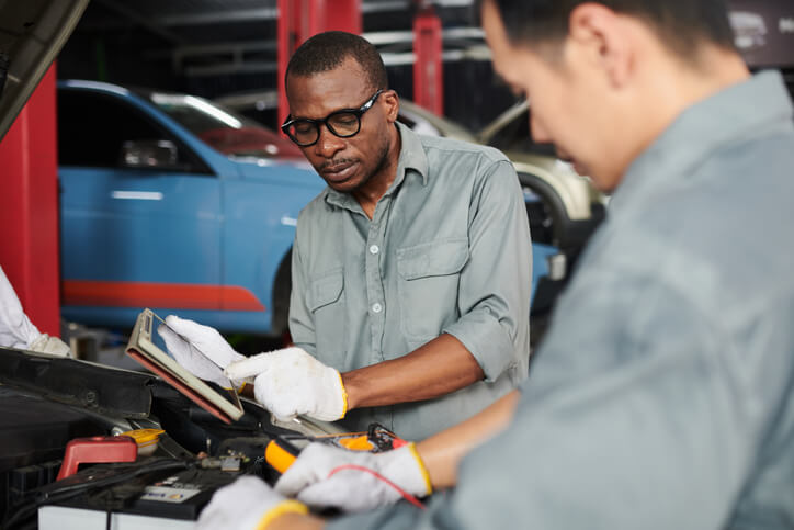 A student learning driveline diagnostics in auto mechanic training