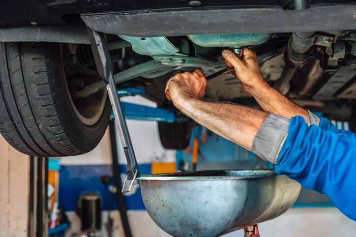 An auto mechanic school student practising undercar maintenance and repair