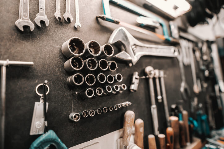 A hands-on automotive training session at a workbench with sockets and torque wrenches laid out.