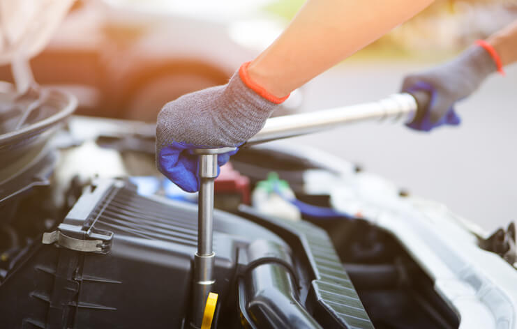 An auto mechanic using a torque wrench during auto mechanic school in Surrey training