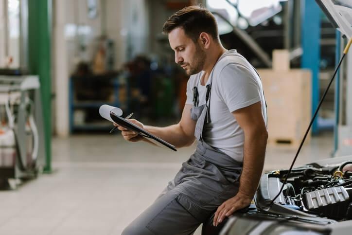 A technician student reviewing repair records and work orders at ATC auto mechanic school in Surrey