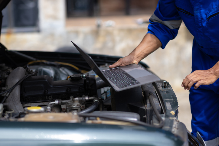 Technician reviewing repair data on a laptop in a Canadian shop.