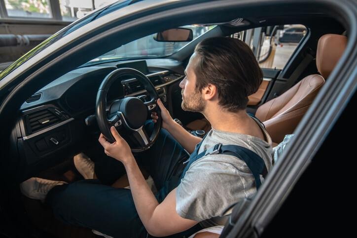 An auto mechanic performing a test drive after vehicle repair