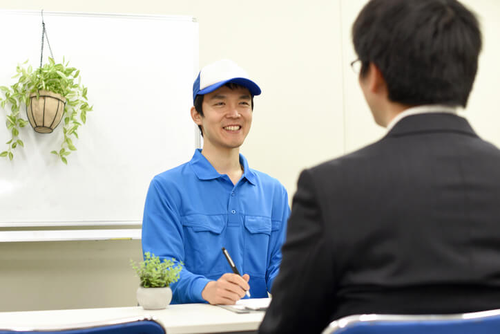 An auto mechanic job candidate asking thoughtful questions during an interview with a shop manager.