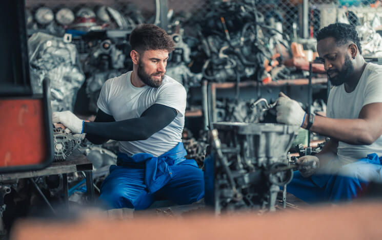 An automotive technician working in a supportive repair shop environment