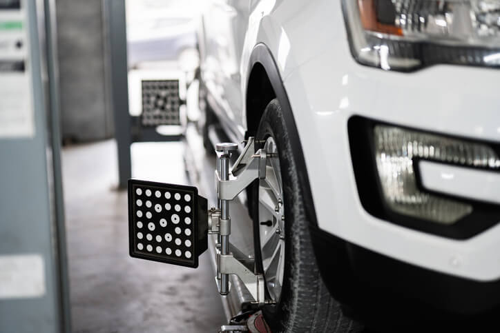 An automotive calibration setup on tires during post-collision repair.