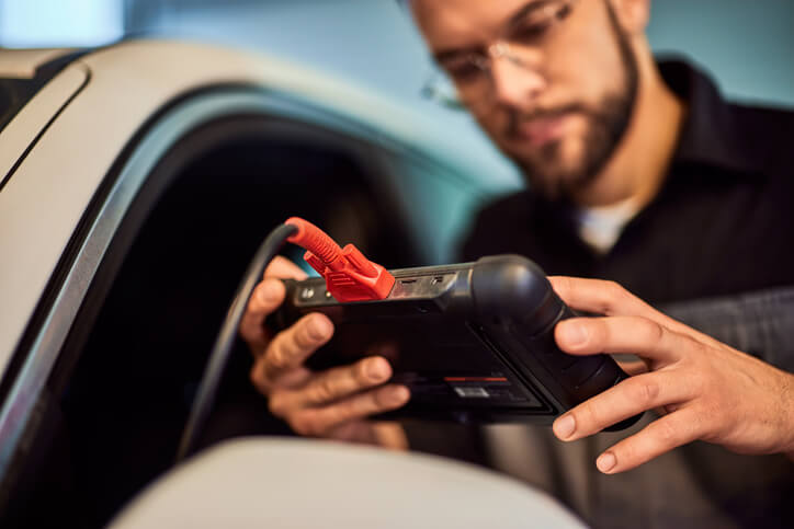 An technician using a scan tool for EV software diagnostics and updates