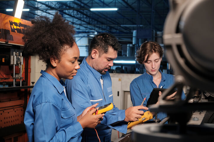 An auto mechanic training student learning high-voltage safety procedures