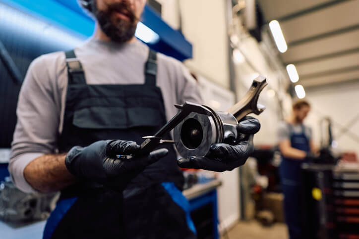 A mechanic looking at remanufactured parts, ensuring reliability is checked during automotive repair