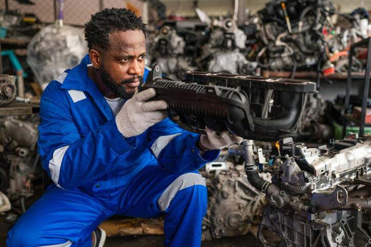 A technician inspecting aftermarket parts before installation