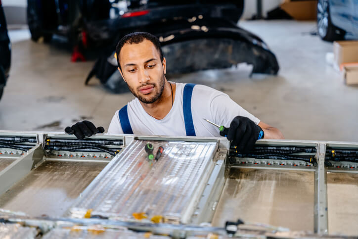 A technician is inspecting an electric vehicle for EV battery water intrusion