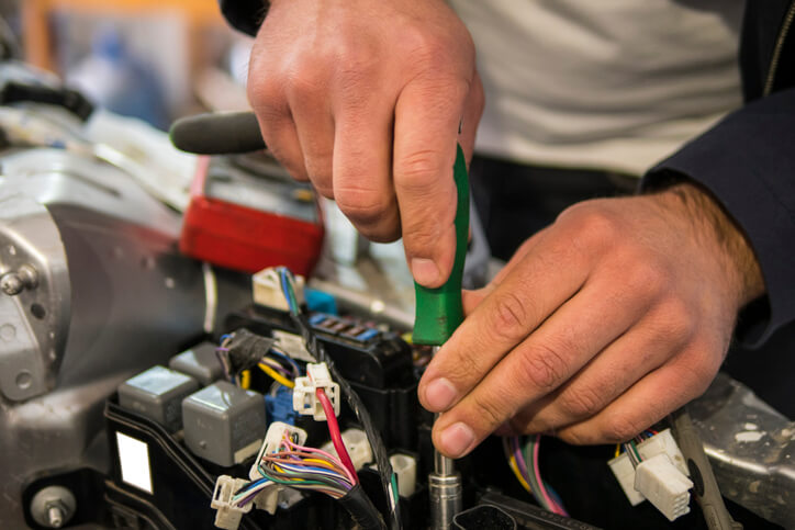 An automotive student practicing terminal repair techniques during training