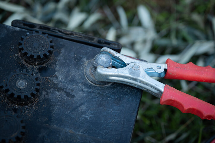 A close-up of the correct clamp placement when learning how to charge a car battery safely