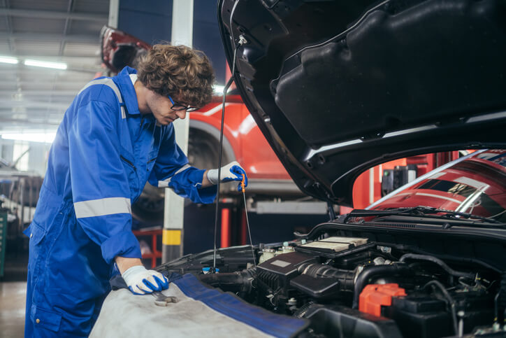 Student performing a basic oil inspection during automotive training