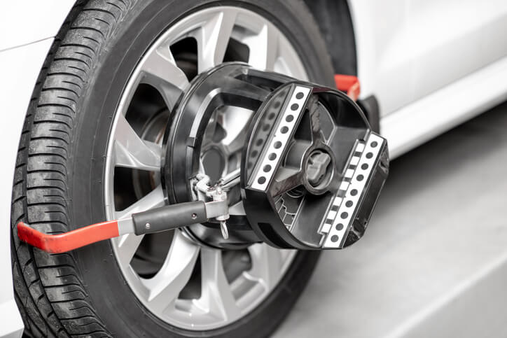 A close-up of wheel alignment sensors mounted on a vehicle wheel during alignment service