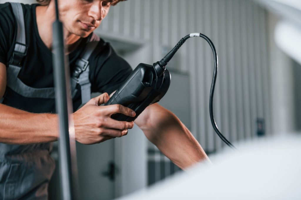 Technician diagnosing the EV thermal management system using a scan tool