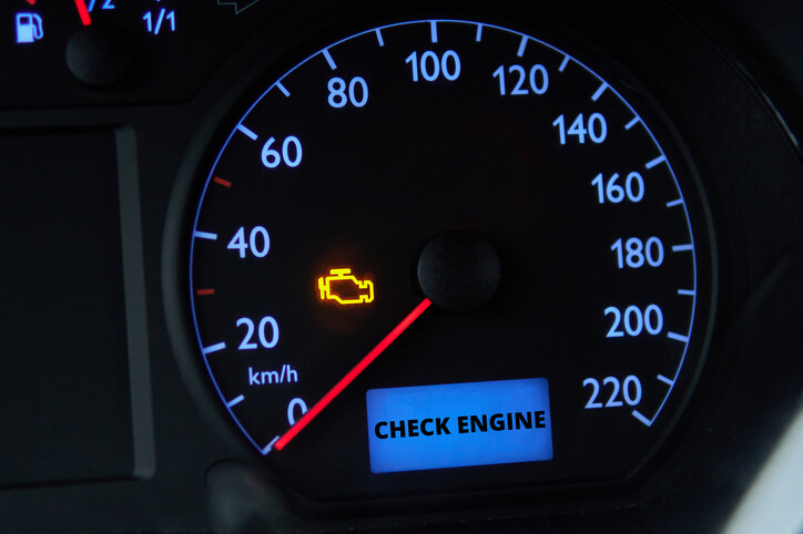 A car dashboard showing a check engine light warning