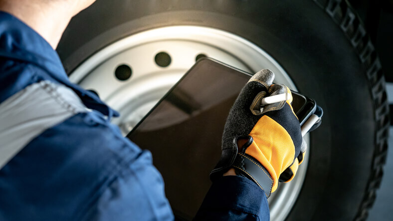 A mechanic performing a TPMS relearn procedure using a scan tool after tire rotation