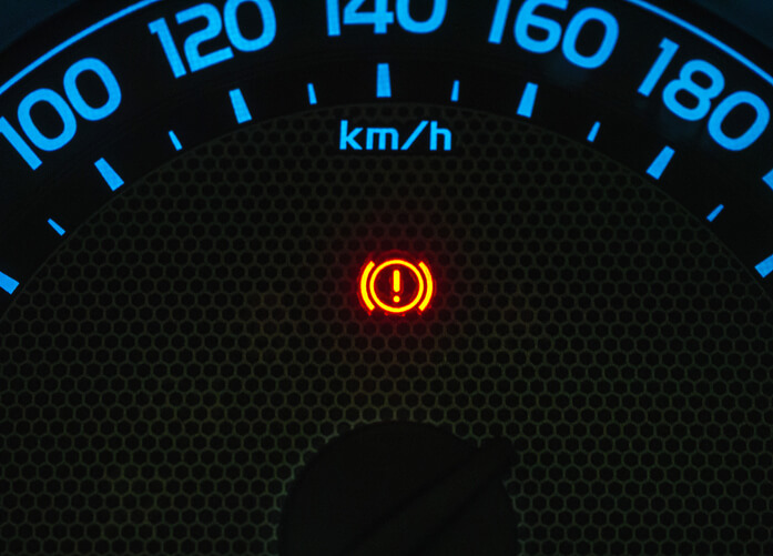 A vehicle dashboard displaying a TPMS warning light during a relearn issue