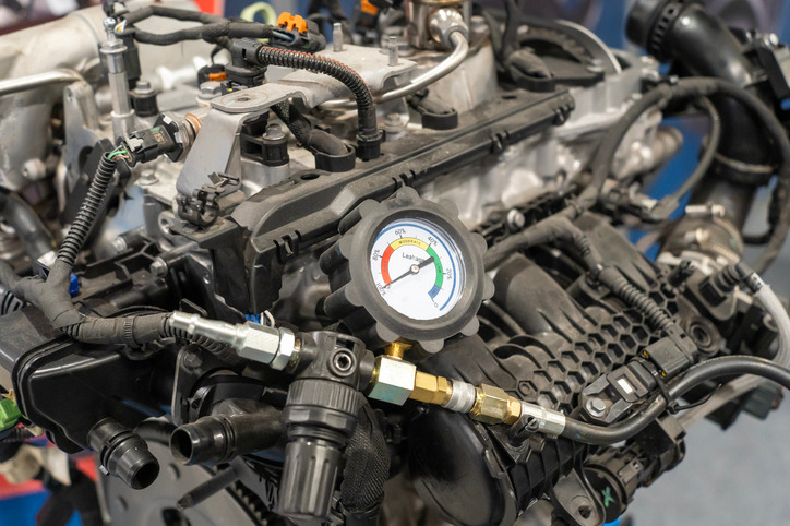 A compression gauge connected to a cylinder head