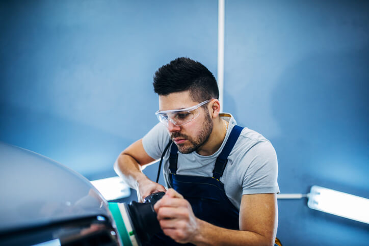 An automotive student performing paint correction during detailing training