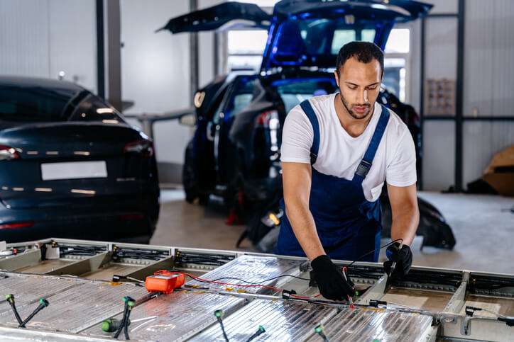 A mechanic working safely on an electric vehicle battery system