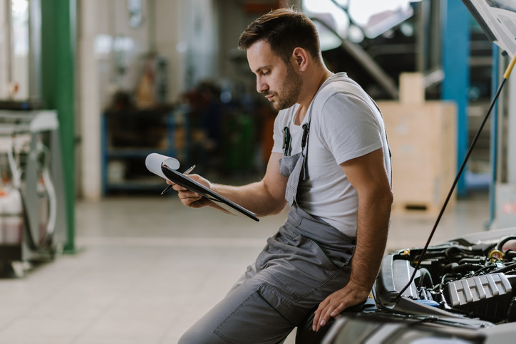 A mechanic analyzing engine test results in a workshop
