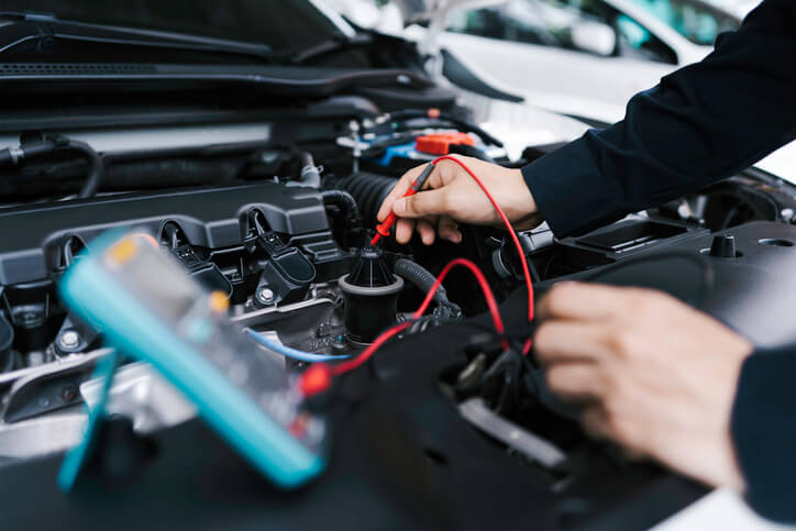 A technician testing a vehicle battery for start-stop system performance and health