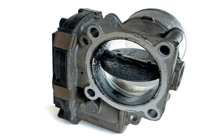 A close-up of carbon buildup inside a throttle body affecting airflow performance