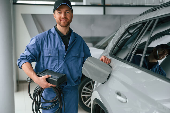 An automotive student learning EV charging diagnostics during technician training