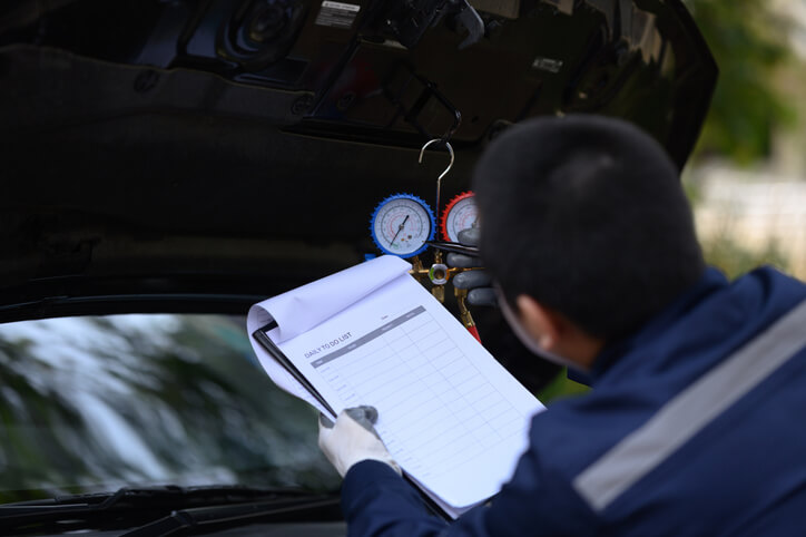 A technician is inspecting an EV heat pump and HVAC system