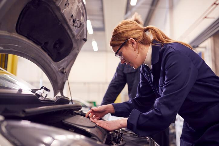 Automotive student learning EV maintenance procedures in a Surrey workshop