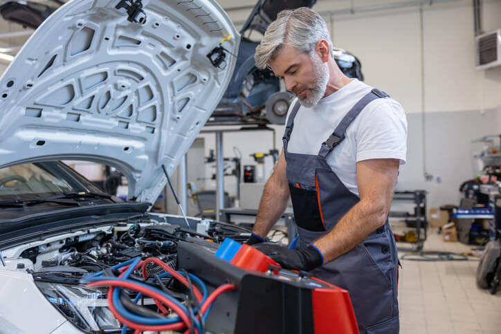 A mechanic inspecting hybrid battery cooling fan components during diagnosis