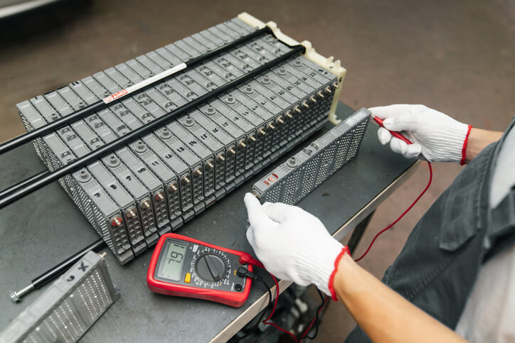 Automotive technician inspecting a high-voltage electric car battery system
