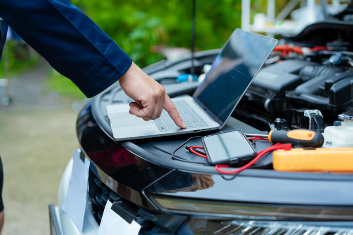 An automotive student using diagnostic tools to investigate an engine misfire