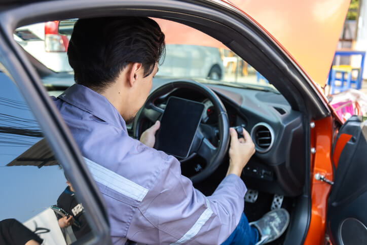 A student learning steering system inspection in an automotive training class