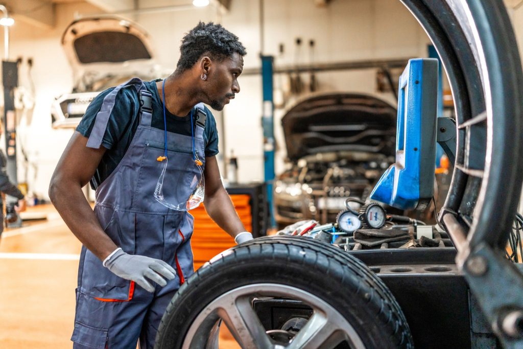 Hybrid vehicle mechanic examining EV tires in a repair shop