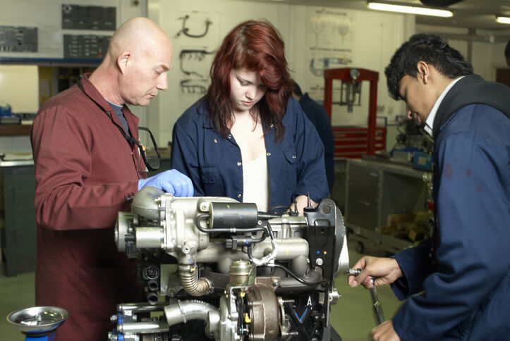 Student in automotive training testing engine air intake components