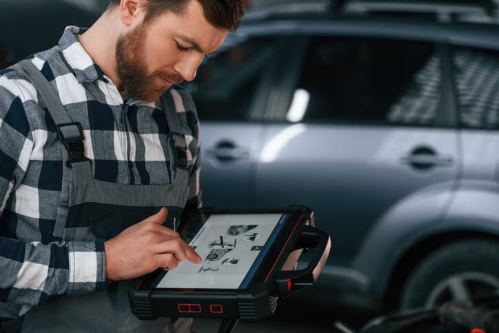 An auto mechanic using advanced scan tools during vehicle service