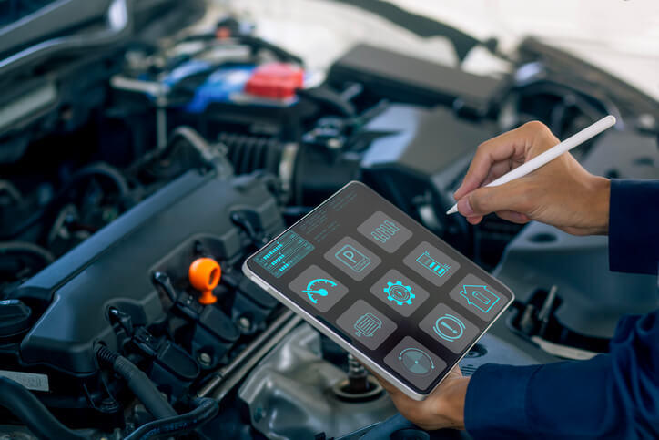 Technician inspecting vehicle components in a professional service facility