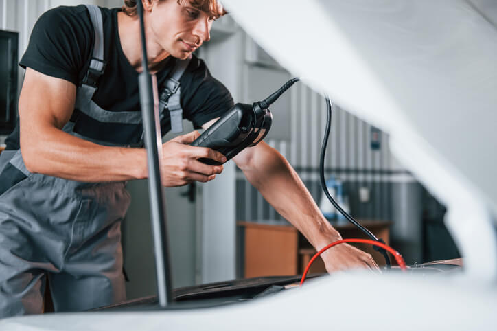 A technician using a diagnostic scanner to troubleshoot an electric vehicle system