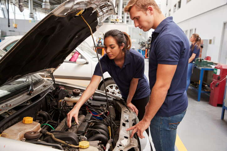 An automotive instructor explaining high-pressure fuel components to students