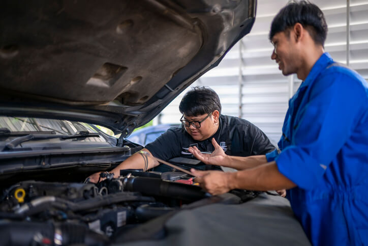 A technician explaining transmission downshifting and engine braking during automotive training