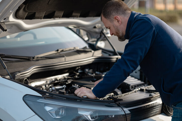Technician examining engine components in a modern vehicle
